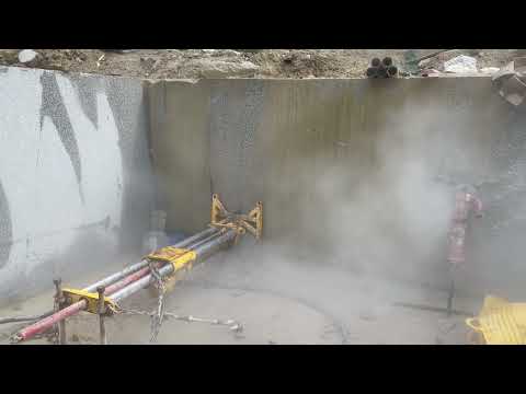 Video: the pneumatic rig drives a 75mm ballistic bit horizontally into the bench face. This bore has to meet the vertical hole drilled from the top of the bench; set the rig a few millimetres out and it can miss by a long way.