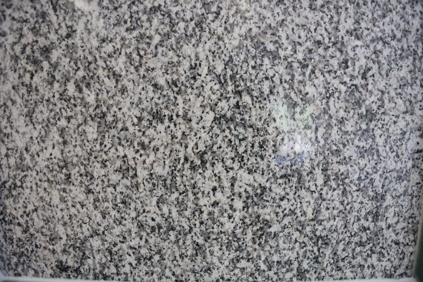De Lank Cornish granite polished finish — A mirror-like surface revealing the full mineral composition of the granite. Bes