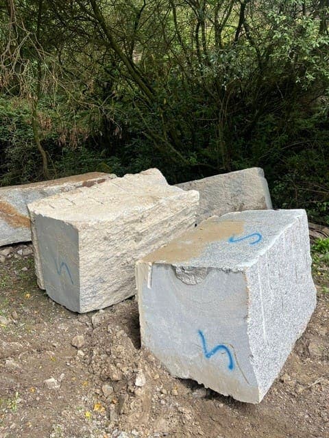 Squared De Lank granite blocks, numbered and freed from the bench, waiting to go down to the saws